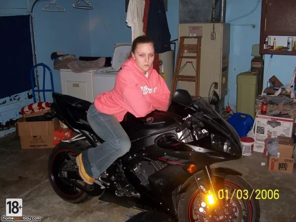 Возбужденная молодуха позирует с мотоциклом в гараже